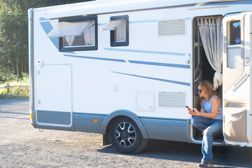 One independent travel woman enjoying vanlife lifestyle sitting outside her motor home camper van...