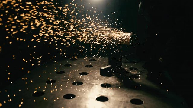 Slow motion: laser cutting, working with a metal workpiece with sparks in a factory. Metalworking, machining, industry, equipment, technology, production concept