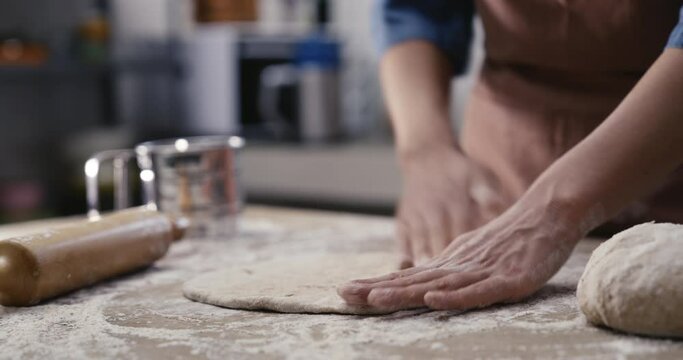 Woman hands kneading dough in the kitchen
