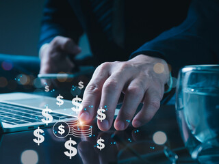 A businessman is using a laptop and a tablet for the display. The subject is success, money, and profit management in the workplace.