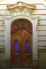 The old, wooden door of tenement with carved decorative architectural element.
