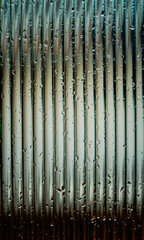 Obraz premium Window glass surface with a strip pattern in the rain. Shot in close up with selective focus. Great for background and pattern designs.