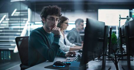 Young Handsome Software Developer Working on Computer in a Technological Laboratory Environment. IT...