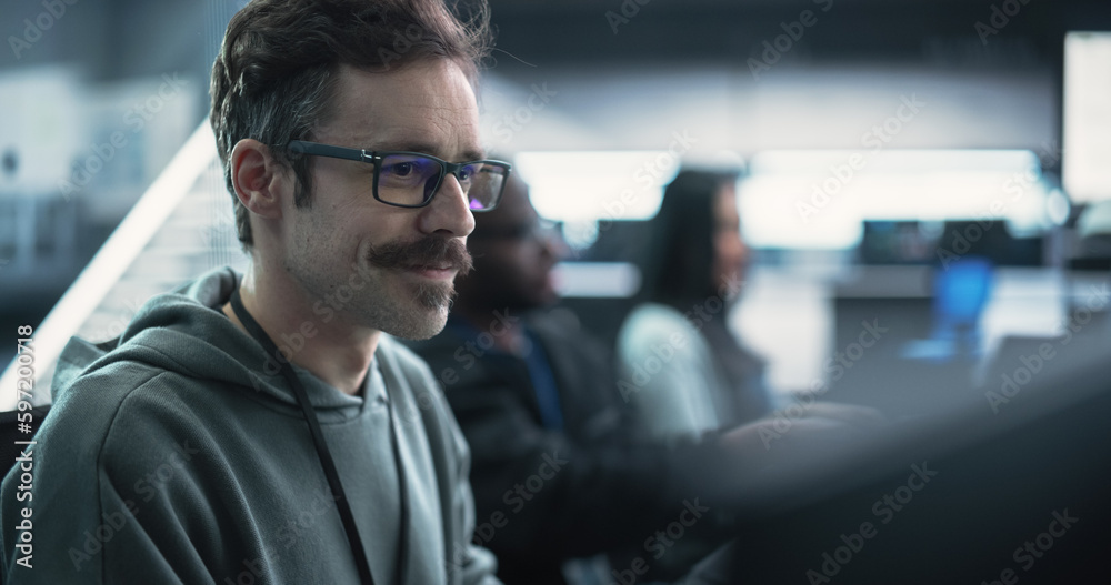 Poster Portrait of a Happy Mustachioed Computer Science Team Member Working on a Computer in a Research and Development Technological Center Facility. Smiling Man Writing Code for Industrial Software