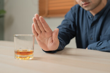 man refuses say no and avoid to drink an alcohol whiskey , stopping hand sign male, alcoholism treatment, alcohol addiction, quit booze, Stop Drinking Alcohol. Refuse Glass liquor, unhealthy, reject