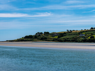 Fototapeta premium blue sky with white clouds over the sea coast in Ireland. Seaside landscape on a sunny summer day, body of water under blue sky.