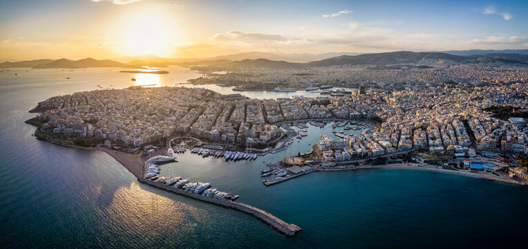 Aerial panorama of the Piraeus district in Athens, Greece, with Zea Marina and the ferry boat harbour in the background during sunset time