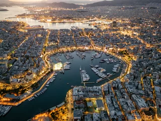 Tuinposter Aerial view of the illuminated Zea Marina in Piraeus, Athens, Greece, with lined up sailing boats and yachts during evening © moofushi