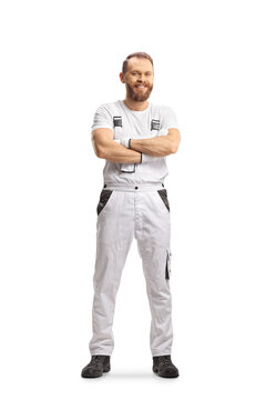 Full length portrait of a house painter in white overall pants posing with crossed arms