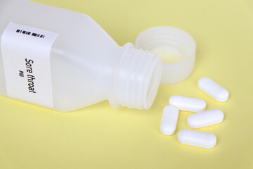 Sore throat pill in white bottle, pill stock