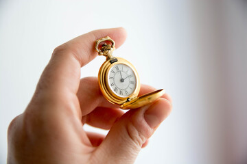 Mano sosteniendo reloj de bolsillo antiguo. Dorado. Copy space. Concepto tiempo.