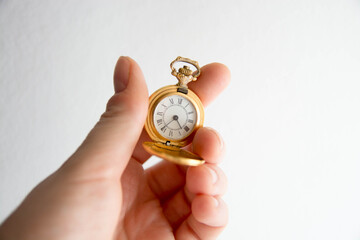 Mano sosteniendo reloj de bolsillo antiguo. Dorado. Copy space. Concepto tiempo.
