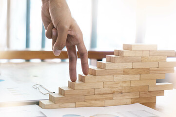 Success concept with business woman hand climbing wooden block stairs in  Business Concept