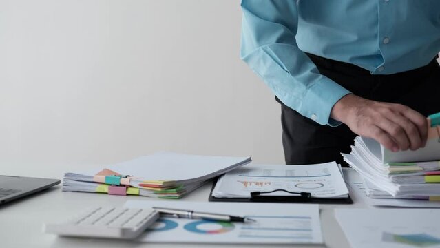 Close up view of businessman working with stack of document papers on the table.