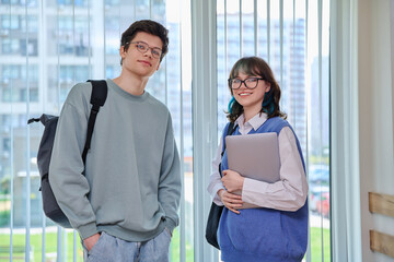 Portrait of two college students, guy and girl looking at camera