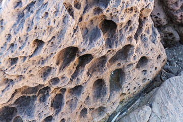 unusual rock formations of the volcanic cliff on Cala Sapone beach, quartz-trachitic ignimbrites.