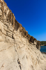 Fototapeta premium unusual rock formations of the volcanic cliff on Cala Sapone beach, quartz-trachitic ignimbrites.