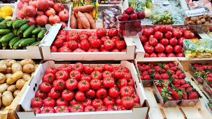ripe tomatoes in cardboard boxes on the vegetable counter in the store, food for buyers