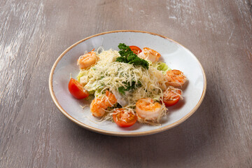 Shrimp salad in a plate on a brown background.