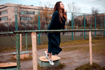 beautiful girl hipster with dreadlocks outdoors wearing trendy green long dress.