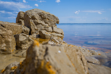 clay shore on a pond in sunny weather with sky reflection in the water