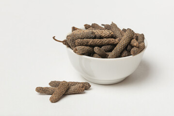 Fruits of the long pepper or pippali in white bowl isolated