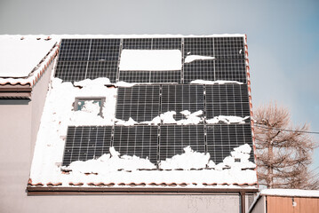 panele słoneczne na dachu, a na nich rozpuszczający się śnieg - obrazy, fototapety, plakaty