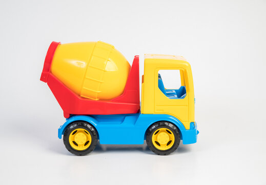 Plastic toy models of construction vehicles. Concrete mixer on a white background.