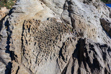 unusual rock formations of the volcanic cliff on Cala Sapone beach, quartz-trachitic ignimbrites.