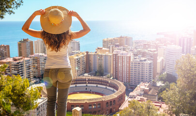 Woman looking at panoramic view of Malaga city in Spain - obrazy, fototapety, plakaty