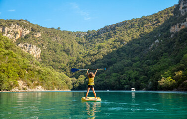 Happy child boy stand up on paddle boarding- lake in France, Verdon