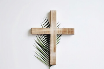 The combination of a cross and palm leaves on a white wooden background is a symbolic representation of Easter, representing the Christian faith's central message of Jesus Christ's resurrection.
