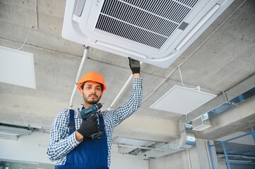 specialist cleans and repairs the wall air conditioner