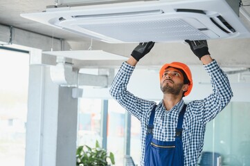 specialist cleans and repairs the wall air conditioner