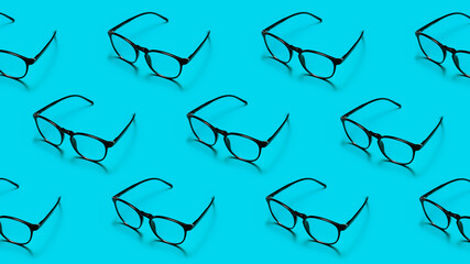 Modern black framed reading glasses or spectacles repeated on a bright blue background with minimalist style.