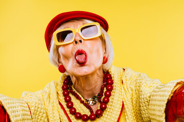 Cool and stylish senior old woman with fashionable clothes - Elderly funny female with stylish colorful dress portrait on isolated colored background - obrazy, fototapety, plakaty