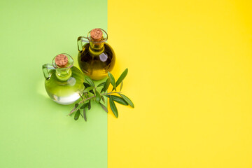Transparent flasks with extra virgin olive oil with an olive branch on a yellow and green background