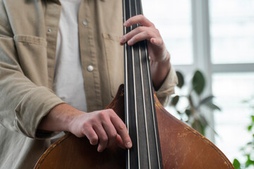 Double bass. Hands playing contrabass player musical instrument. 