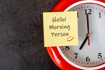 Clock and adhesive note with text and smiling icon - Hello Morning person