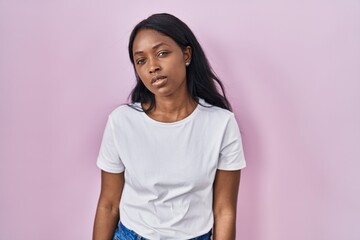 African young woman wearing casual white t shirt looking sleepy and tired, exhausted for fatigue and hangover, lazy eyes in the morning.