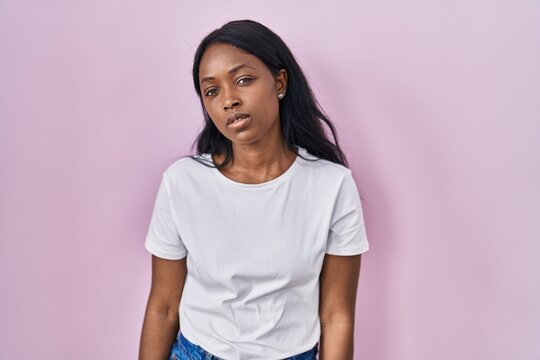 African young woman wearing casual white t shirt looking sleepy and tired, exhausted for fatigue and hangover, lazy eyes in the morning.