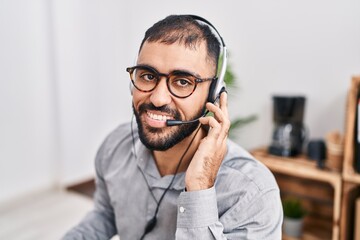 Young hispanic man call center agent smiling confident working at office
