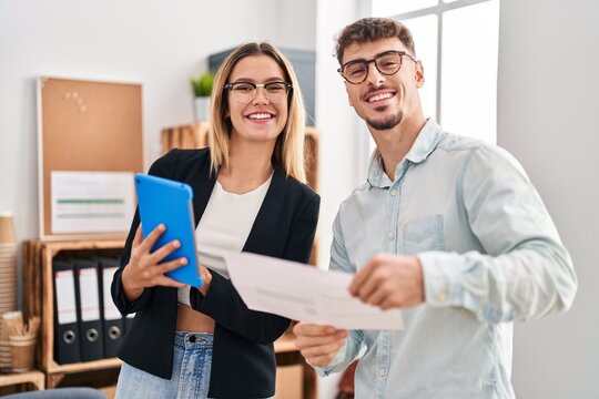 Young man and woman business workers using touchpad working at office
