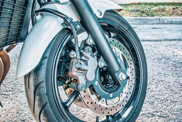 Obraz premium The front wheel of a racing motorcycle on the road.