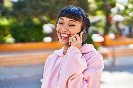 Young woman smiling confident talking on the smartphone at park