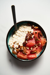 Overnight oats with milk and greek yogurt. healthy breakfast with nuts with grapefruit, honey and cinnamon. Top view