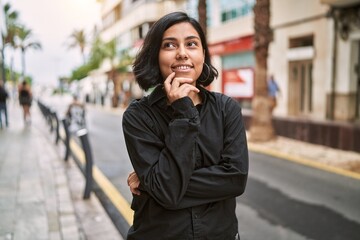 Young latin woman smiling confident standing with arms crossed gesture at street