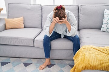Obraz premium Young woman stressed sitting on sofa at home