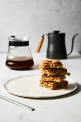 blondie cookies squares on white plate. Composition of sweet breakfast with coffee and blondie cookies.