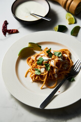 Plate with Mexican pasta. Pasta with tomato sauce with chilli puree, feta and cream cheese. Spaghetti macaroni boiled al dente and mixed with sauce